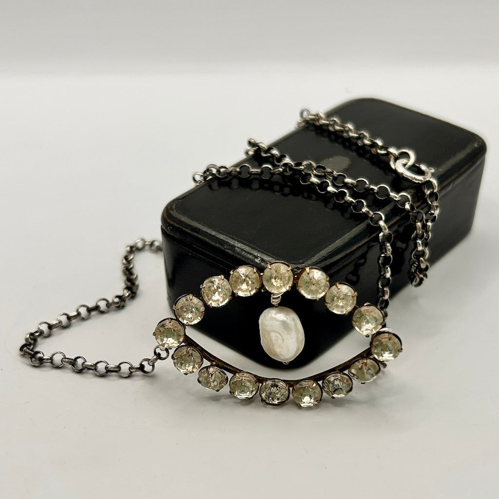 Black rectangular box  with a chain necklace  featuring gemstones and a pearl wrapped around it by Badgers Velvet 