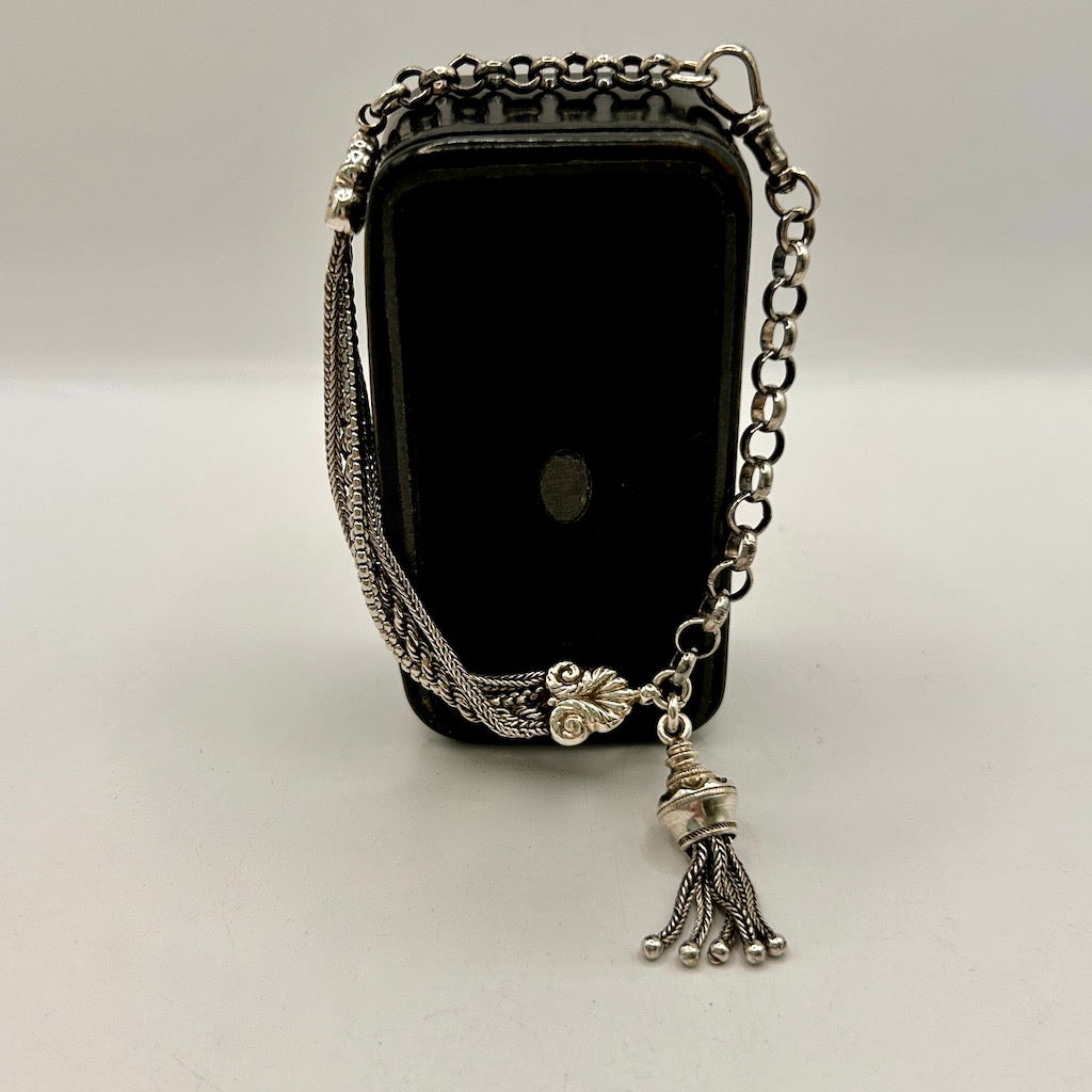 Black stone with silver chain and tassel on a white background